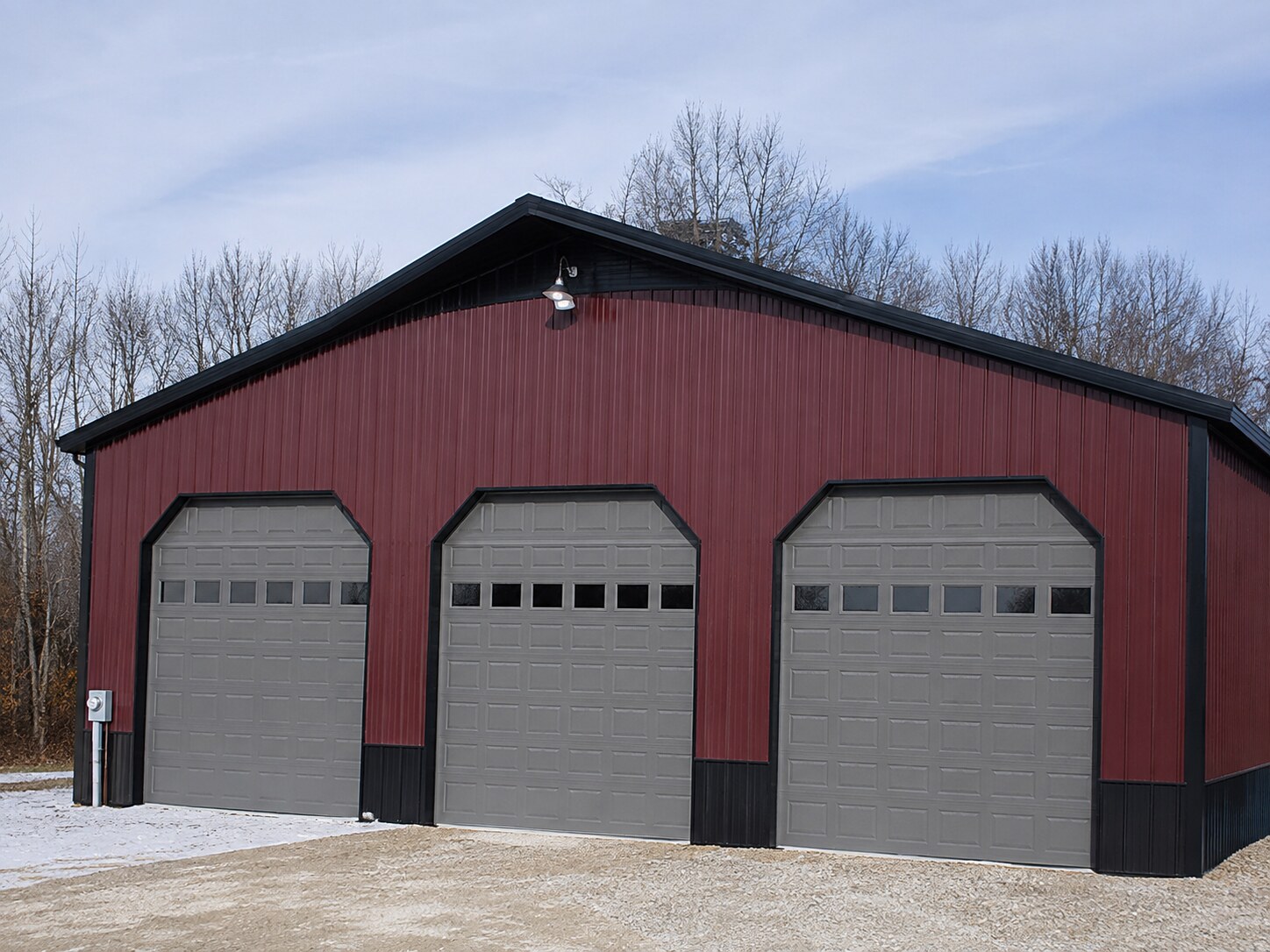 White barn with open lean-to and a red pickup truck