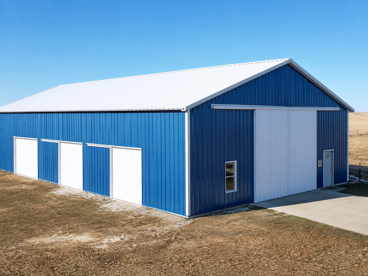 Blue and white post-frame farm building with overhead doors