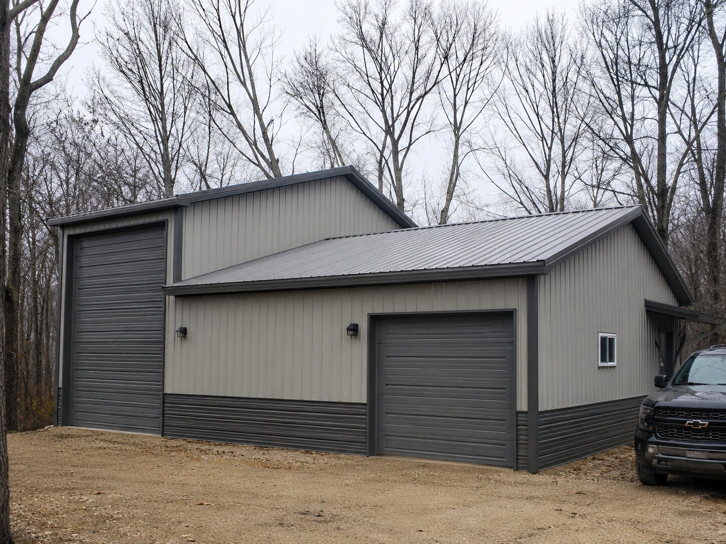 White barn with gable dormer, cupolas and overhead door