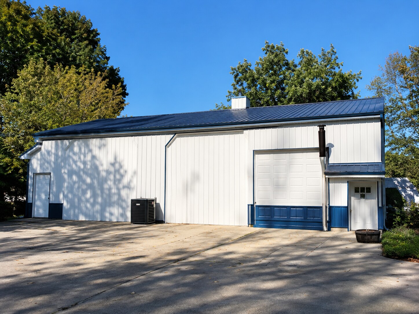White commercial post-frame shop with paved parking lot