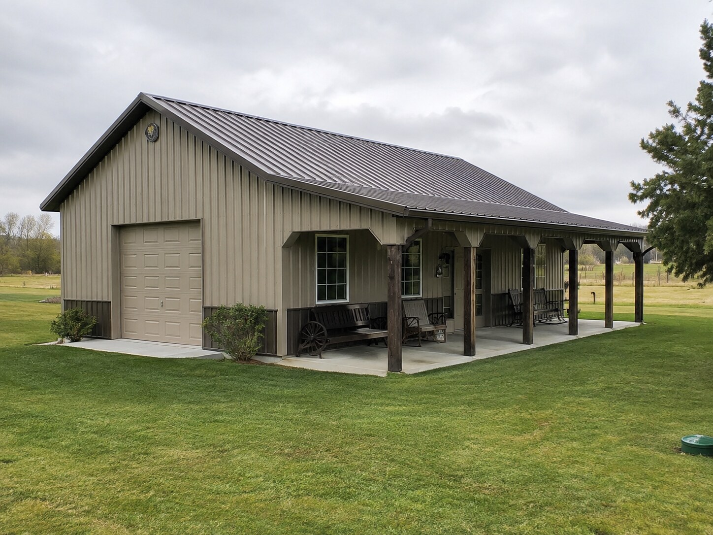 White two-story post-frame barn home with wood accent doors