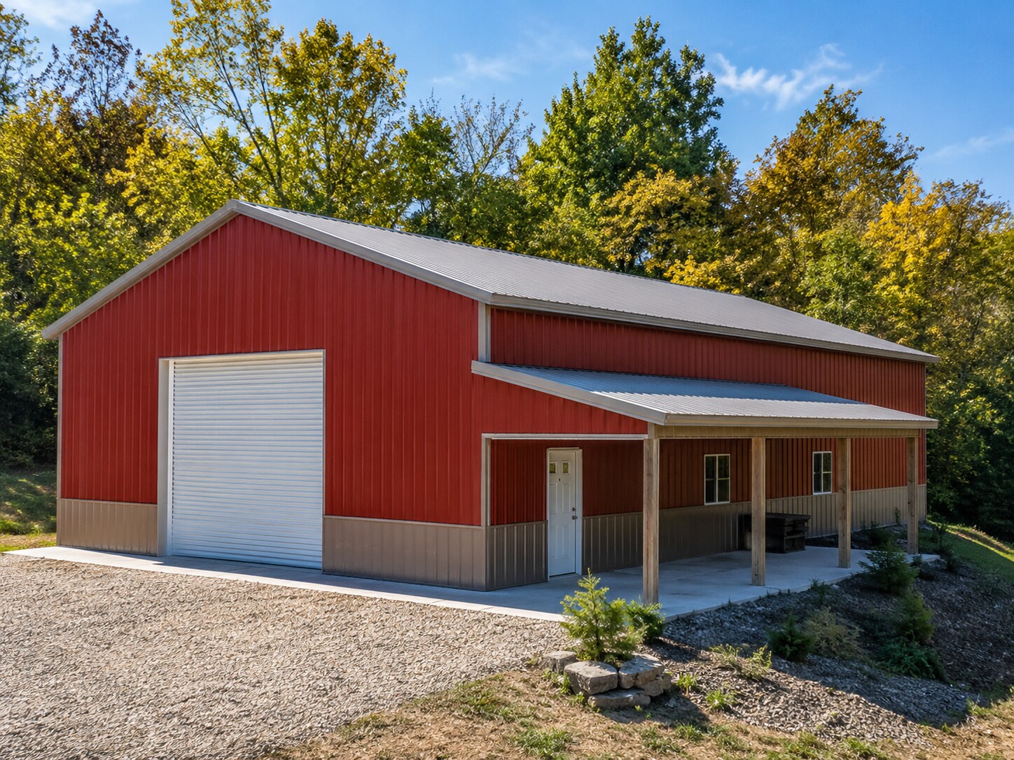 Red barn with white overhead door and open lean-to
