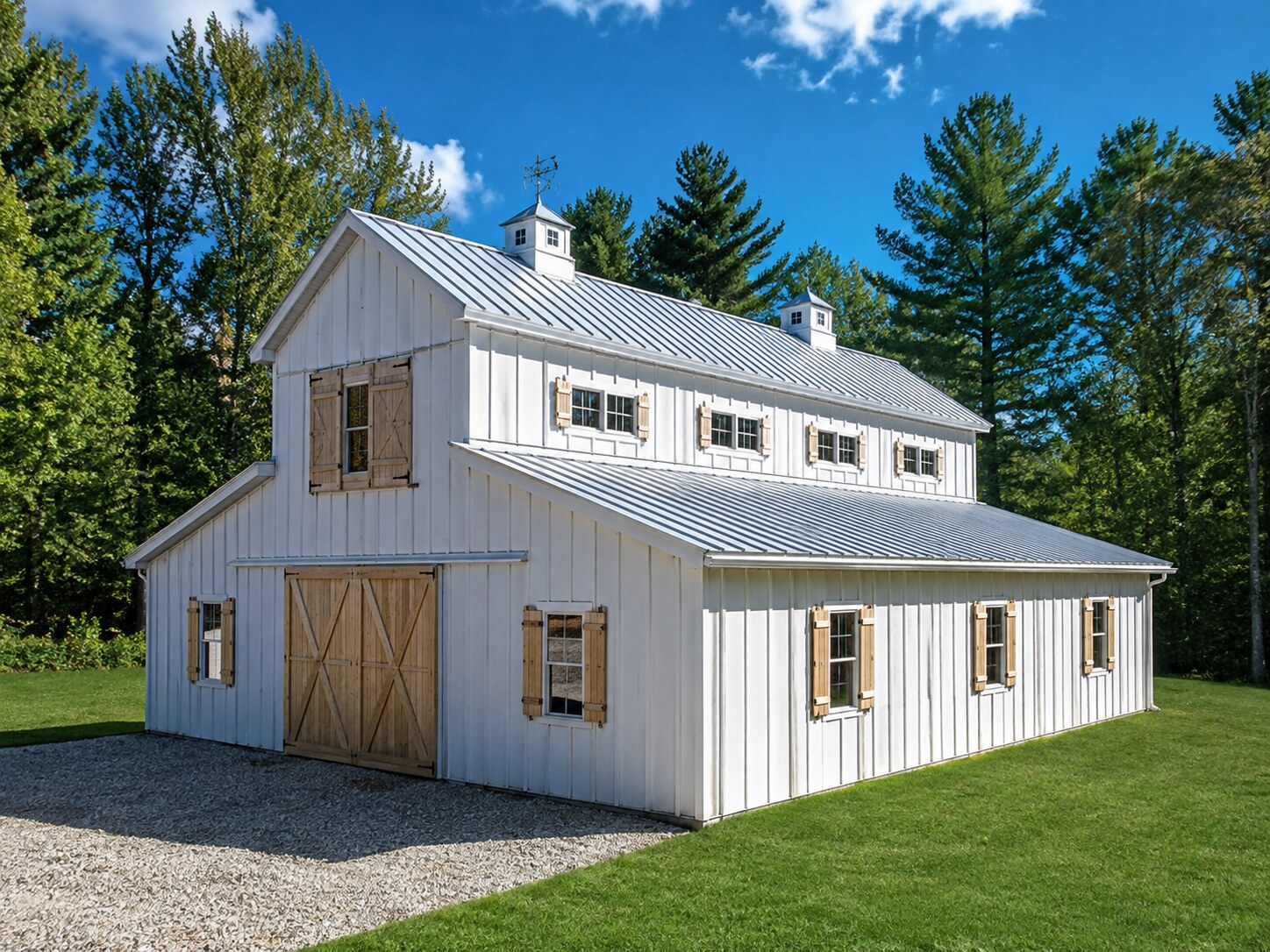 Black post-frame garage with two overhead doors on a gravel pad